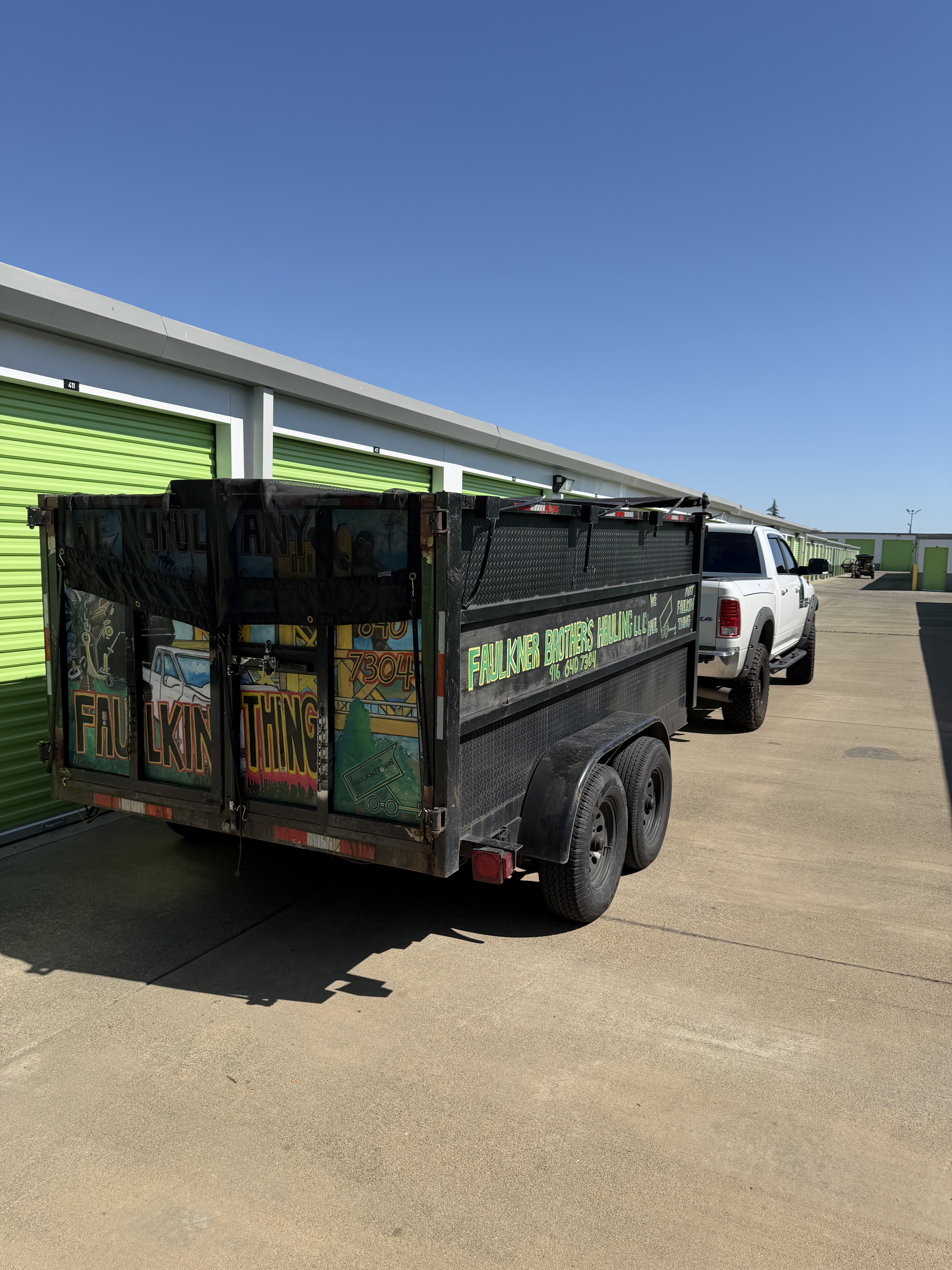 Faulkner Brother's Hauling dump trailer with company lettering hitched to a white pickup truck